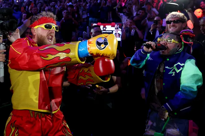 MIAMI, FLORIDA - DECEMBER 19: 6ix9ine sings as he walks with Jake Paul to the ring prior to his heavyweight bout against Anthony Joshua in Jake Paul v Anthony Joshua at Kaseya Center on December 19, 2025 in Miami, Florida. (Photo by Ed Mulholland/Getty Images for Netflix)