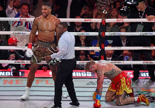 MIAMI, FLORIDA - DECEMBER 19: Anthony Joshua knocks down Jake Paul in their heavyweight bout during Jake Paul v Anthony Joshua at Kaseya Center on December 19, 2025 in Miami, Florida. (Photo by Carmen Mandato/Getty Images for Netflix)