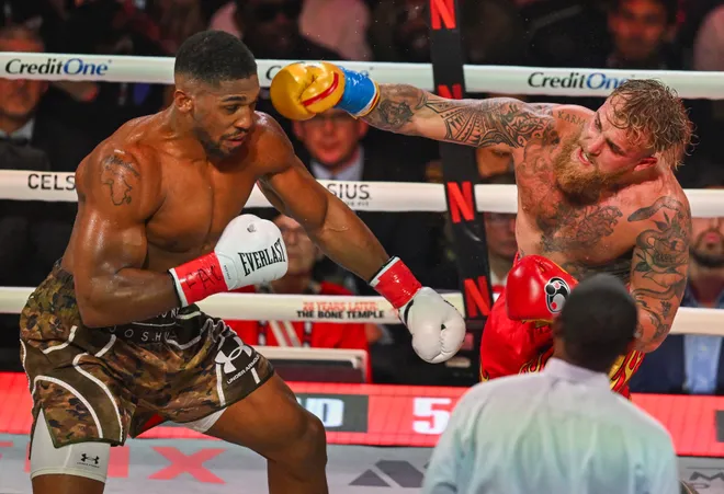 US boxer and influencer Jake Paul (R) and British boxer Anthony Joshua fight in a non-title heavyweight bout at the Kaseya Center in Miami, Florida on December 19, 2025. (Photo by Giorgio VIERA / AFP via Getty Images)