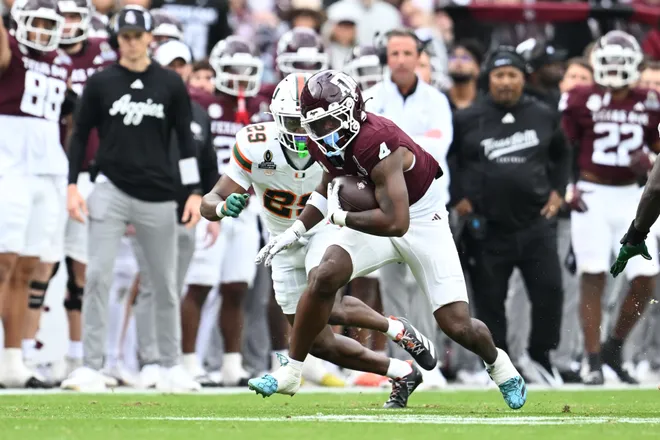 Dec 20, 2025; College Station, TX, USA; Texas A&M Aggies running back Rueben Owens II (4) runs the ball against Miami Hurricanes defensive back Jr. Romanas Frederique (29) during first quarter of the first round game of the CFP National Playoff at Kyle Field. Mandatory Credit: Maria Lysaker-Imagn Images