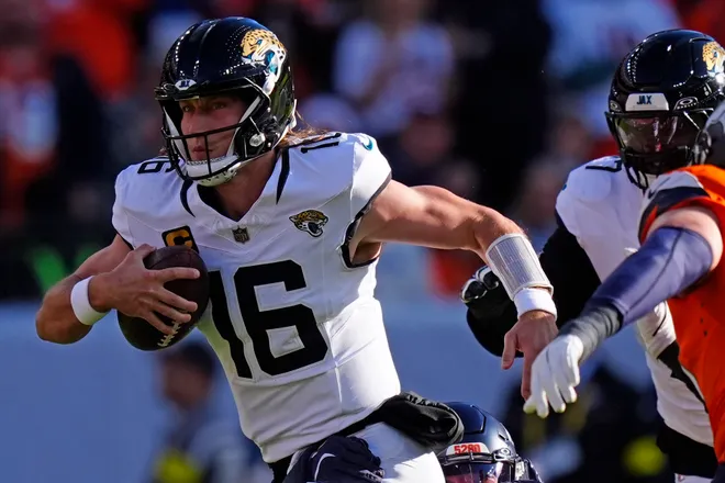 Dec 21, 2025; Denver, Colorado, USA; Jacksonville Jaguars quarterback Trevor Lawrence (16) rushes the ball against the Denver Broncos during the first half at Empower Field at Mile High. Mandatory Credit: Ron Chenoy-Imagn Images