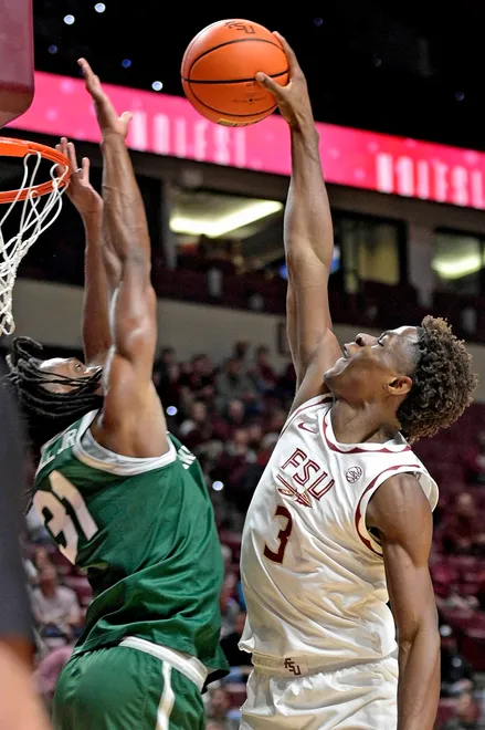 Dec 22, 2025; Tallahassee, Florida, USA; Florida State Seminoles forward Thomas Bassong (3) dunks the ball over Jacksonville University Dolphins forward Jason Thirdkill Jr. (31) during the first half at Donald L. Tucker Center. Mandatory Credit: Melina Myers-Imagn Images