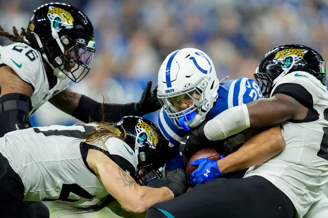Indianapolis Colts running back Jonathan Taylor (28) is brought down by Jacksonville Jaguars defenders Sunday, Dec. 28, 2025, during a game at Lucas Oil Stadium in Indianapolis.