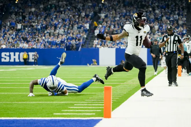 Jacksonville Jaguars wide receiver Parker Washington (11) runs out of bounds in front of Indianapolis Colts cornerback Cameron Mitchell (43) on Sunday, Dec. 28, 2025, during a game at Lucas Oil Stadium in Indianapolis.