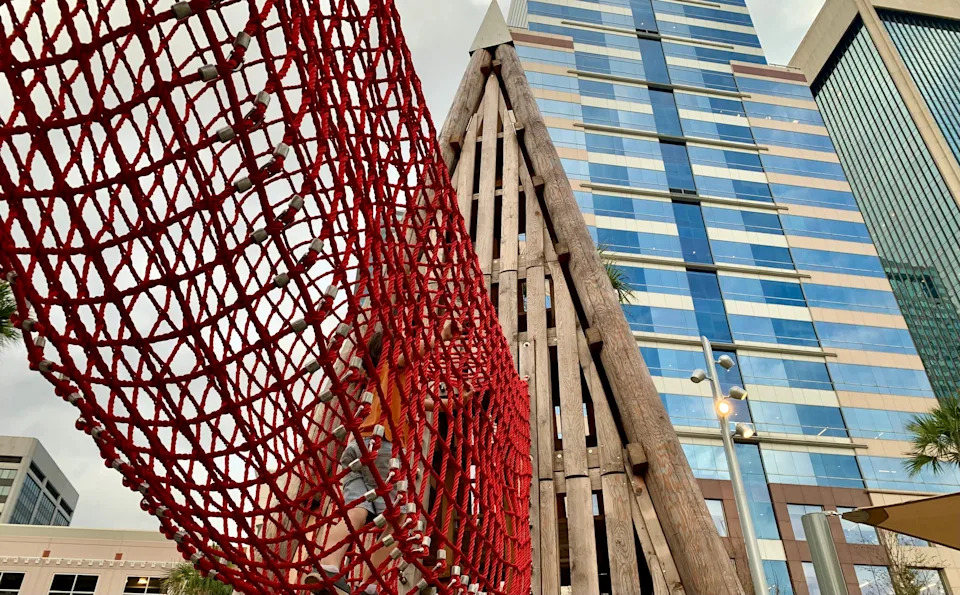 A rope tunnel is one of the ways to get from one tower to the other at Riverfront Plaza, which officially opened Dec. 5, 2025 in downtown Jacksonville. The VyStar Tower is behind the playground's tower.