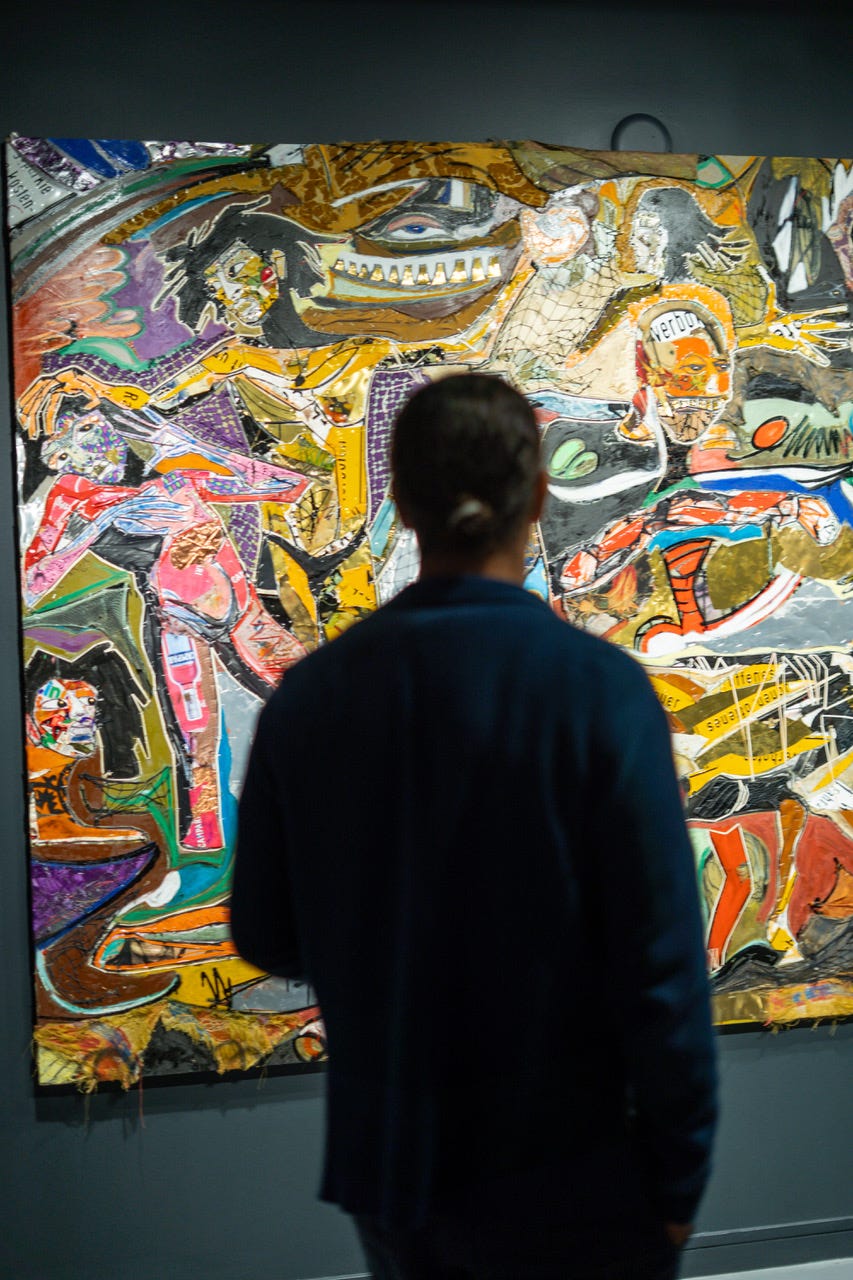 Visitor observing an abstract artwork in a gallery setting.