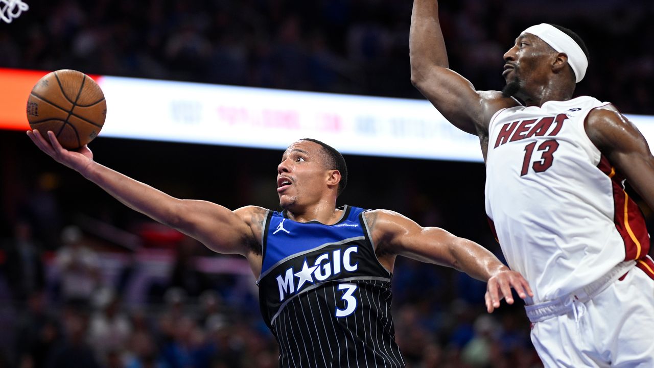 Orlando Magic guard Desmond Bane (3) goes up to shoot as Miami Heat center Bam Adebayo (13) defends during the second half of an NBA Cup basketball game, Tuesday, Dec. 9, 2025, in Orlando, Fla. (AP Photo/Phelan M. Ebenhack)