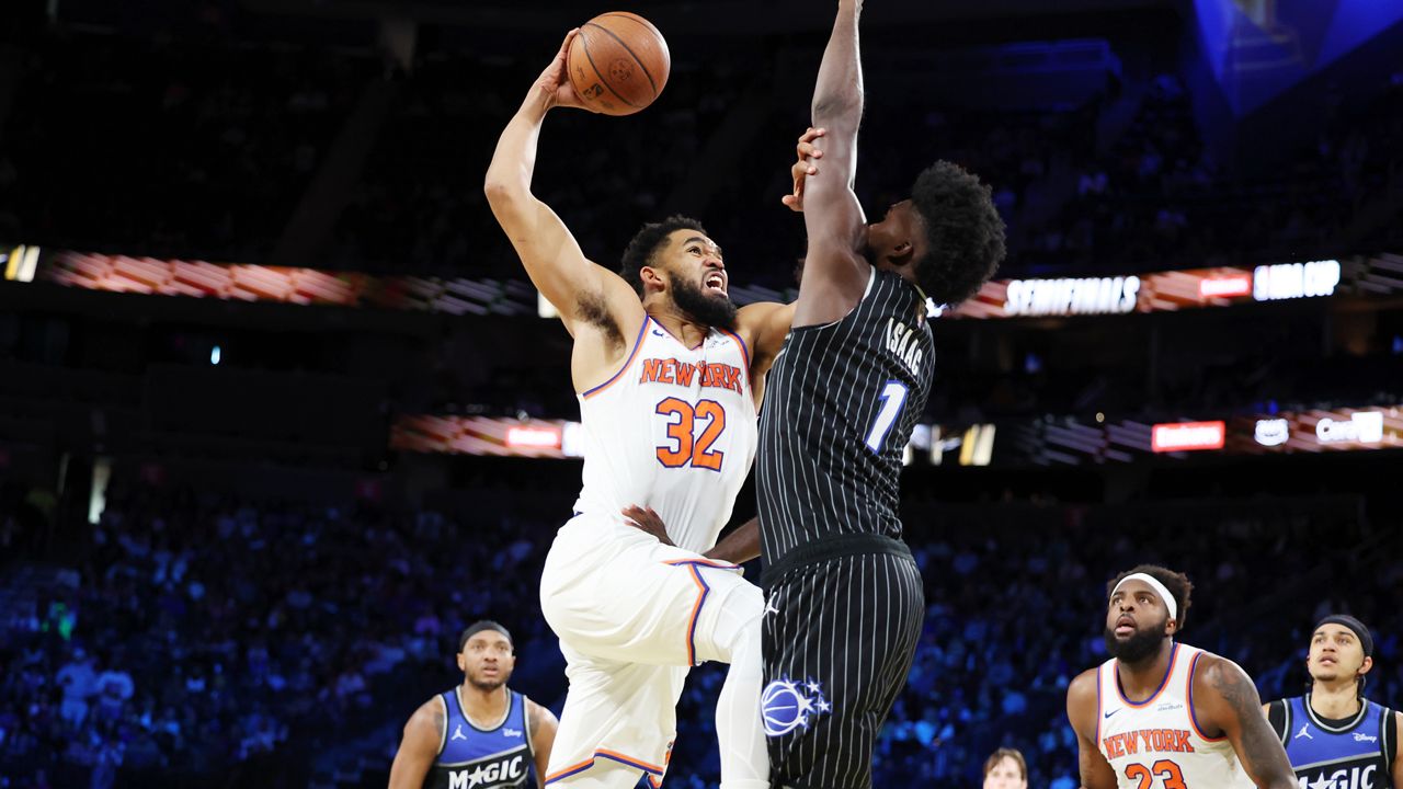 New York Knocks center Karl-Anthony Towns (32) and Orlando Magic forward Jonathan Isaac (1) tangle near the net during the first half of an NBA Cup semifinals basketball game, Saturday, Dec. 13, 2025, in Las Vegas. (AP Photo/Ronda Churchill)