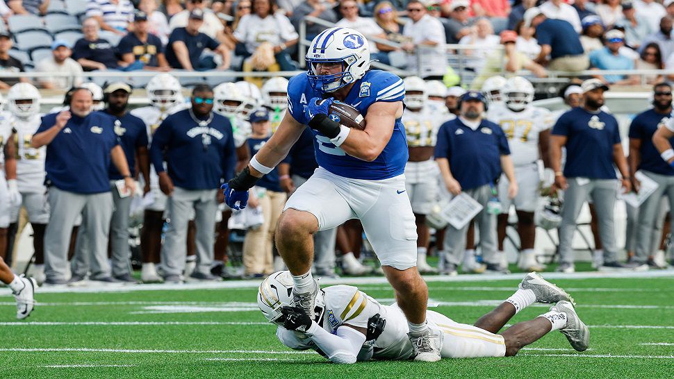 BYU tight end Carsen Ryan (20) is tackled by a Georgia Tech defensive player during the first half of the Pop-Tarts Bowl NCAA college football game Saturday, Dec. 27, 2025, in Orlando, Fla. (AP Photo/Kevin Kolczynski)