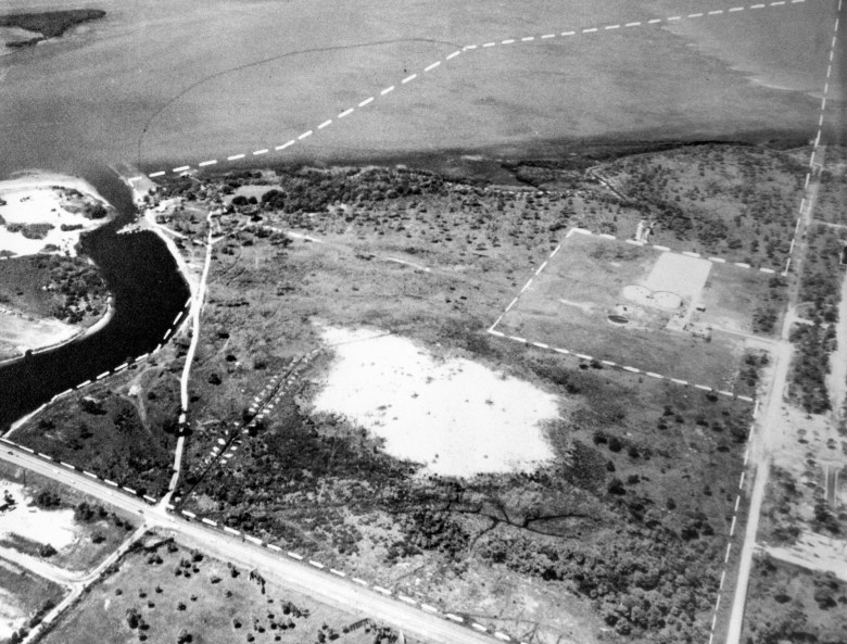 A black-and-white aerial photograph of a largely undeveloped coastal landscape in 1959. Dotted white lines mark out property boundaries or proposed development areas.