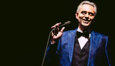 Photo of a man on stage holding a mic wearing a smoking