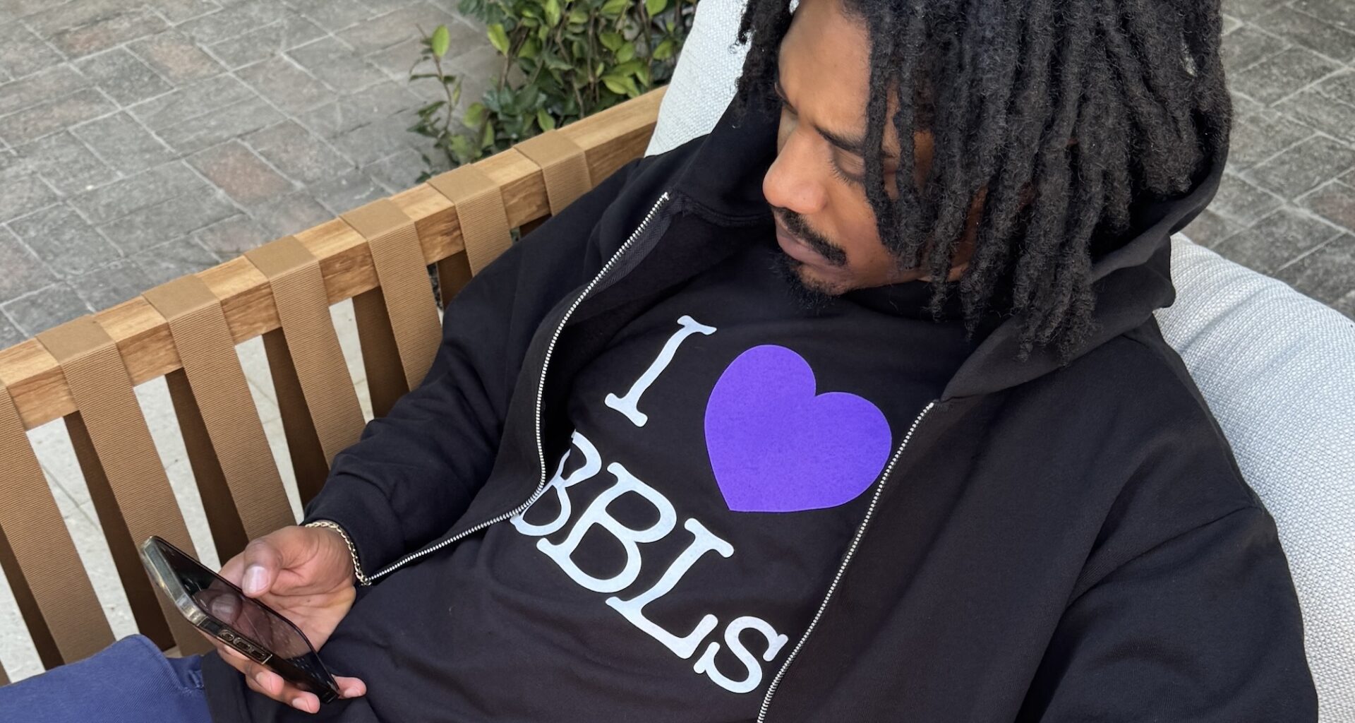 Photo of a man wearing a black T-shirt and jacket. The text on the shirt reads, "I heart BBLs"