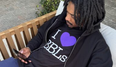 Photo of a man wearing a black T-shirt and jacket. The text on the shirt reads, "I heart BBLs"