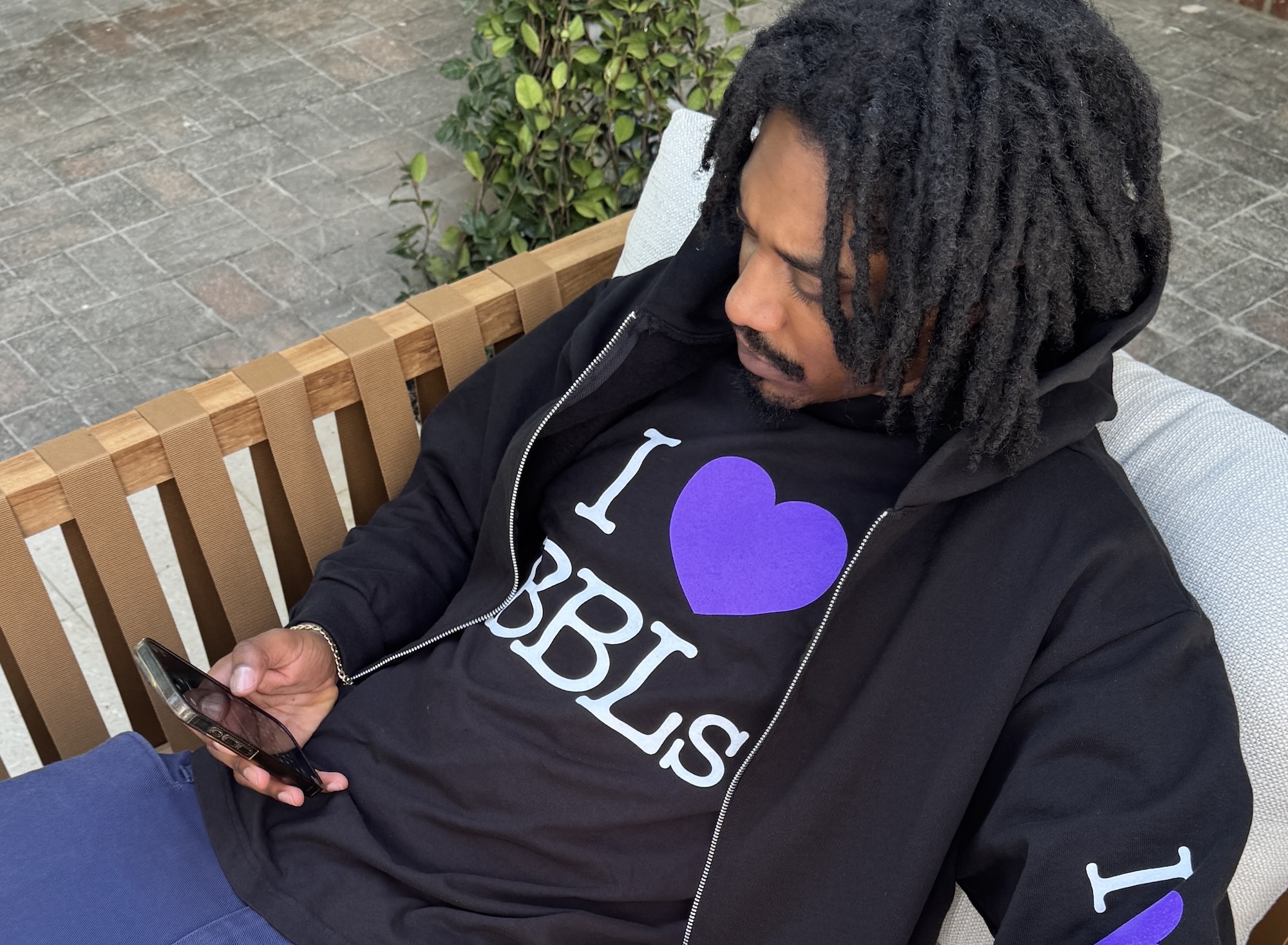 Photo of a man wearing a black T-shirt and jacket. The text on the shirt reads, "I heart BBLs"