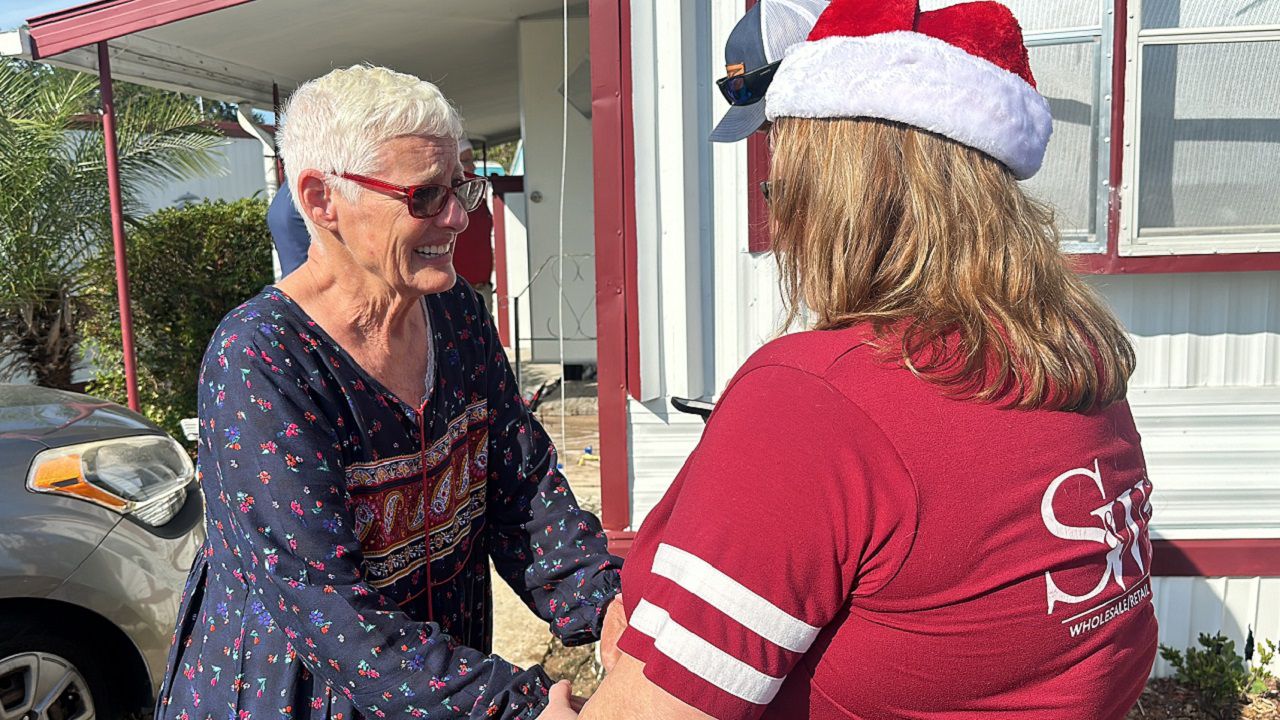 Valeria Hall (left) learns she is the recipient of the Kitchen for Christmas Giveaway. (Spectrum News)