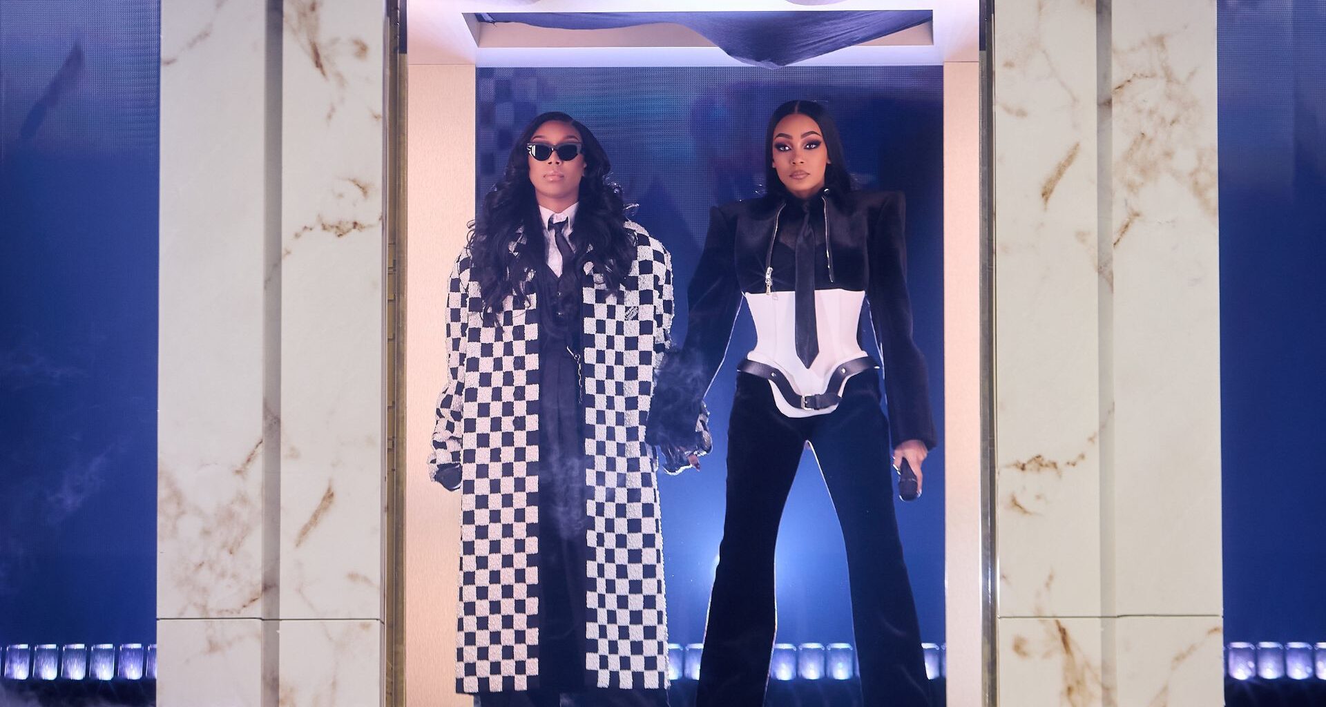 Two woman standing under a door frame holding hands