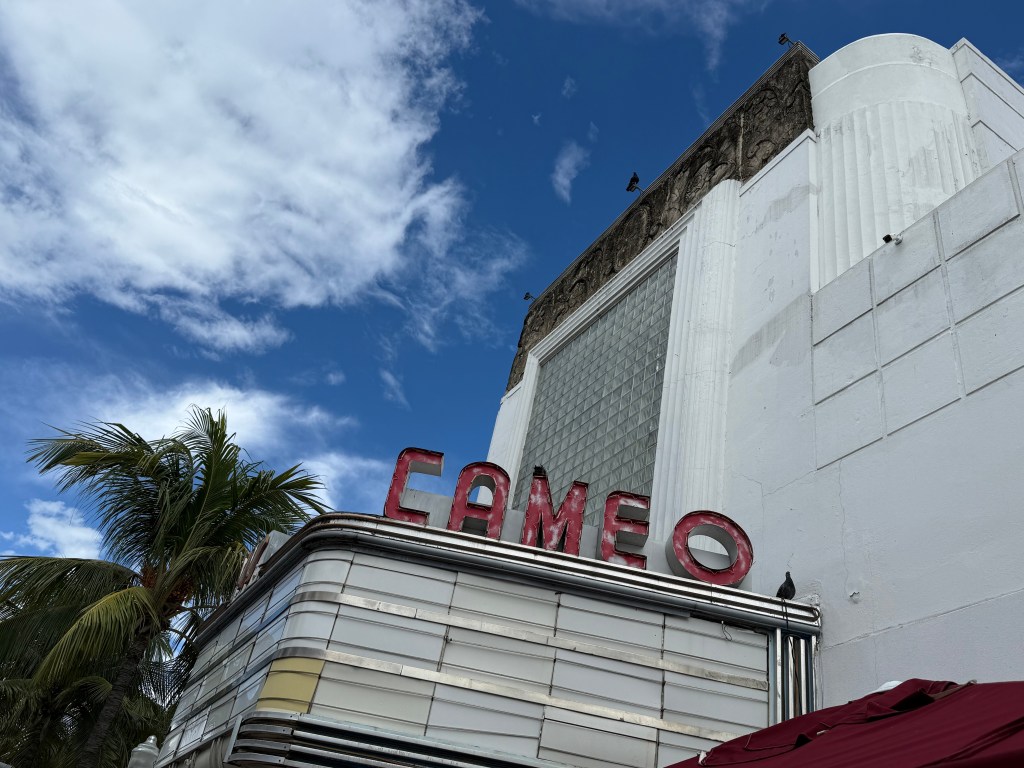 Photo of a marquee without writing. A neon sign above the marquee reads, "Cameo"