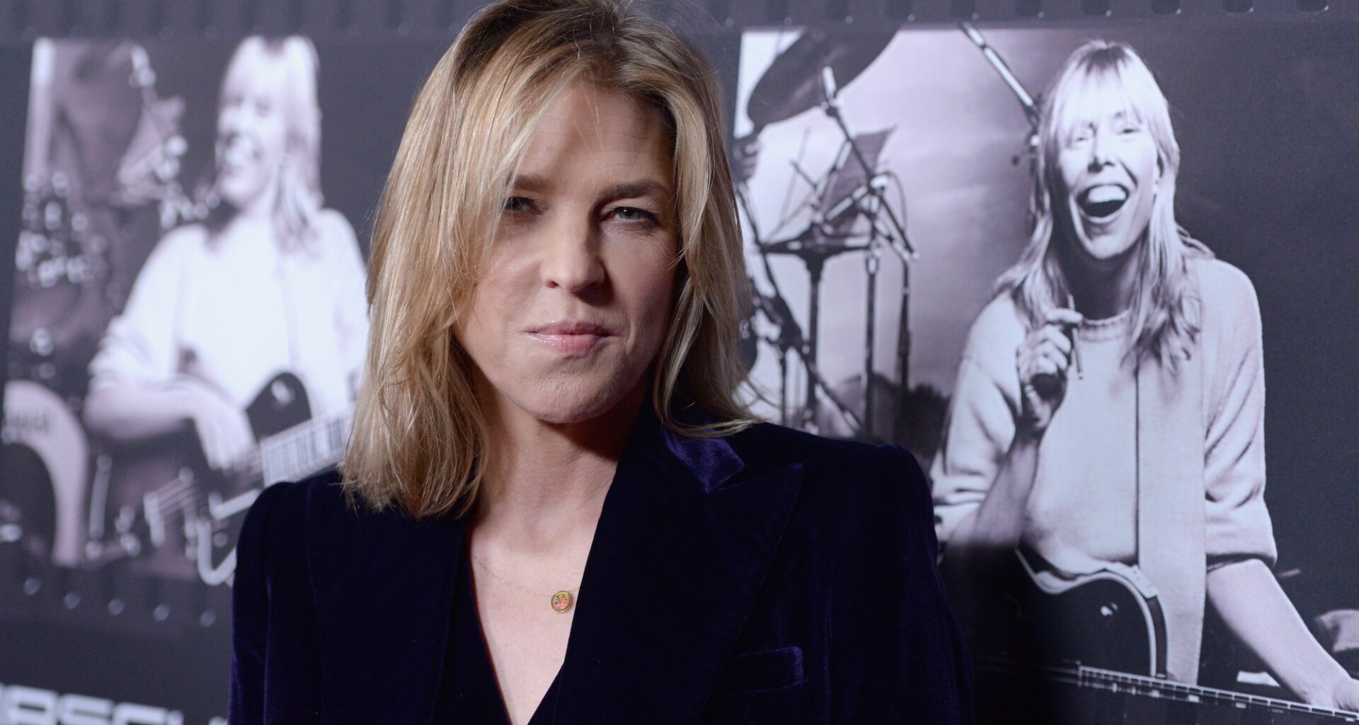 Photo of a blonde woman looking at the camera wearing a black suit.