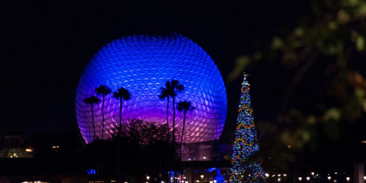 Spaceship Earth glowing blue with Christmas tree in Disney World's EPCOT park