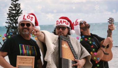 Photo of men wearing christmas hats at the beach.