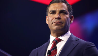 Miami Mayor Francis Suarez wearing a black suit with a white shirt and red tie