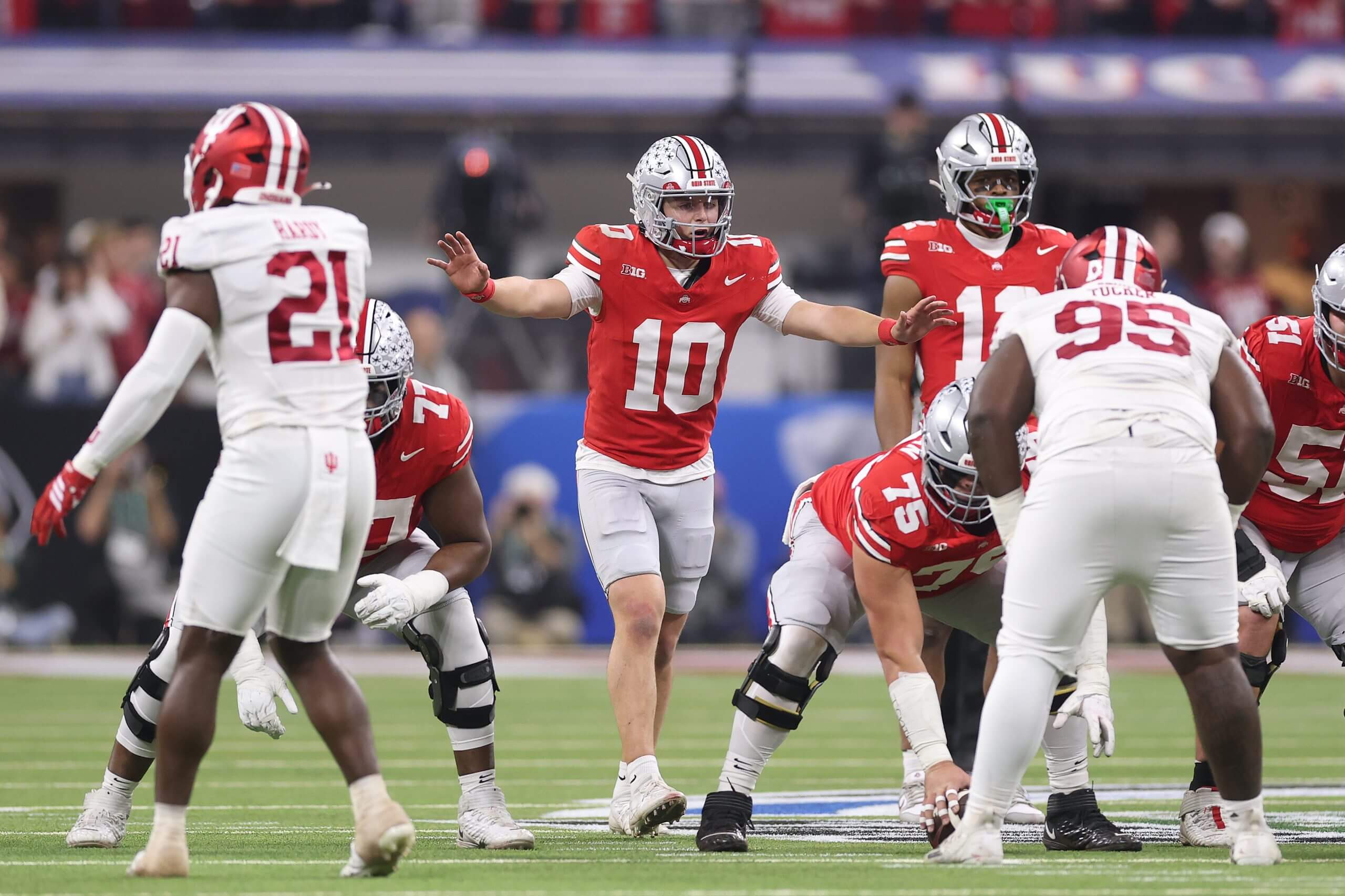 Ohio State quarterback Julian Sayin raises his arms and directs the offense before a snap