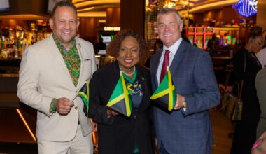 A group of three people holding Jamaican flags