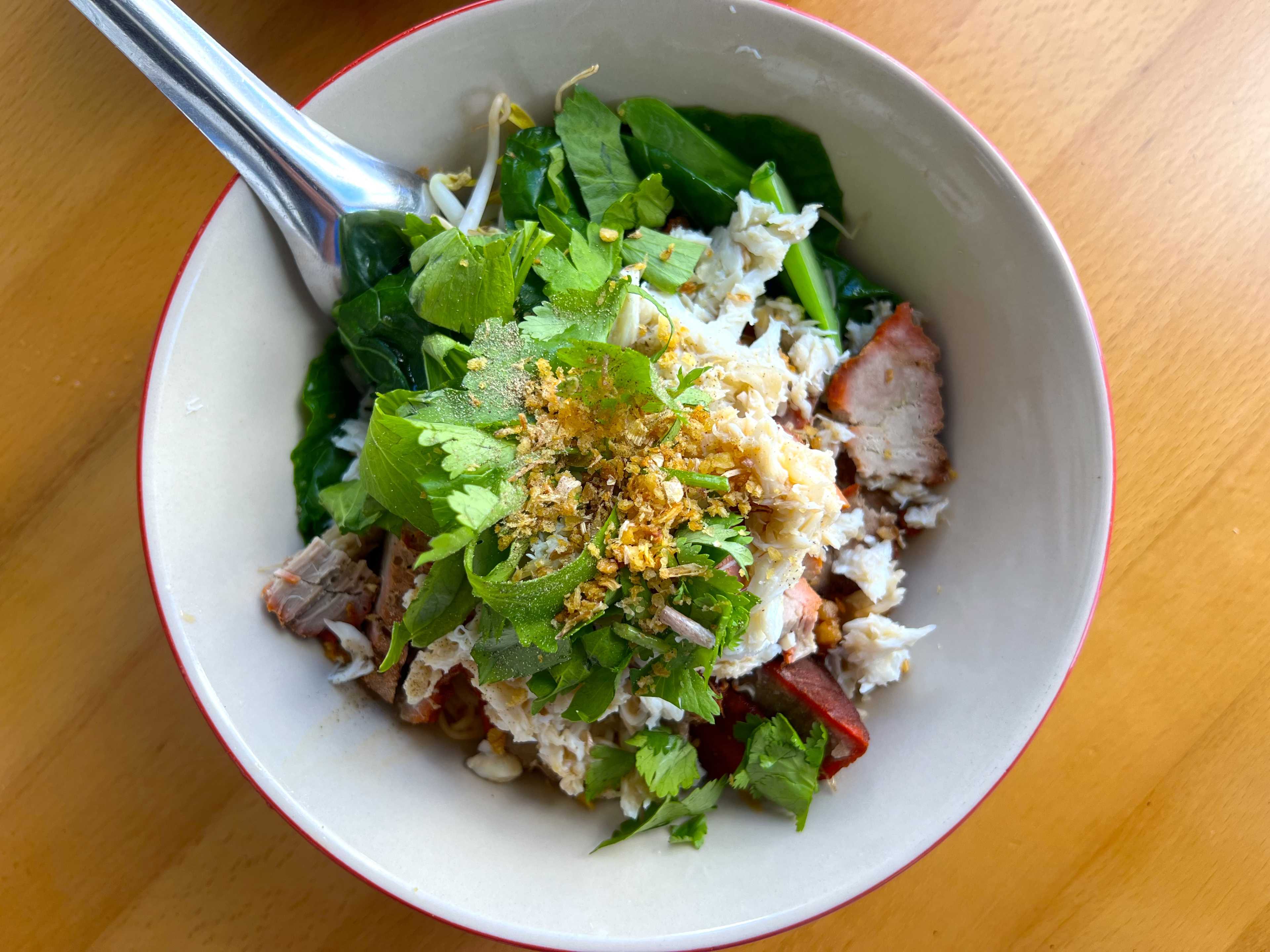 a bowl of noodles and pork.