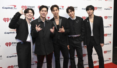 photo of a group of Korean singers in front of a step and repeat.