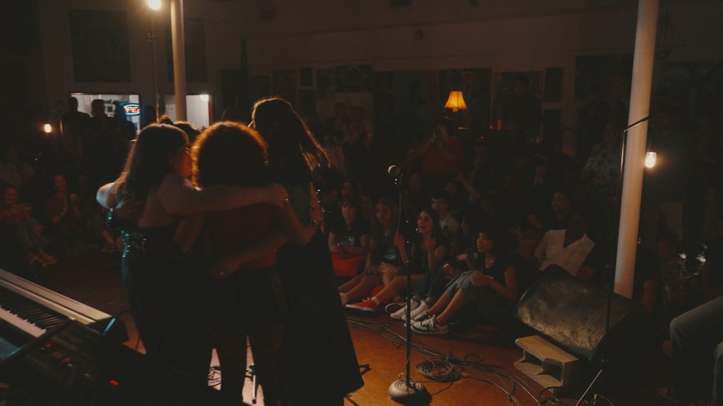 a group of young people hugging on stage