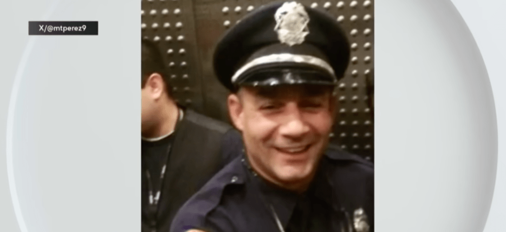 A Miami Police officer wearing his official cap smiles for the camera
