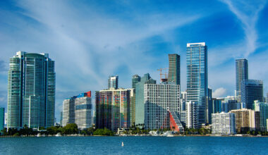 hi-rise condos and skyscrapers from Miami's skyline stand behind a foreground of blue water