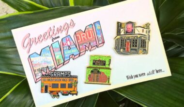 Photo of a postcard that says greetings from Miami and has pins on it.