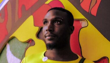 Photo of a man standing by a colorful mural