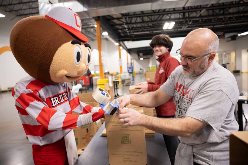 (From left) Ohio State University's mascot Brutus Buckeye helps Will Garcia, 16, and Chris...
