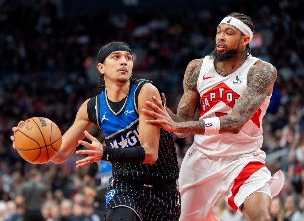 Orlando Magic guard Anthony Black, left, drives against Toronto Raptors' Brandon Ingram, right, during second-half NBA basketball game action in Toronto, Monday Dec. 29, 2025. (Frank Gunn/The Canadian Press via AP)