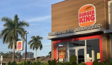 A Burger King store is surrounded by palm trees and South Florida shrubs