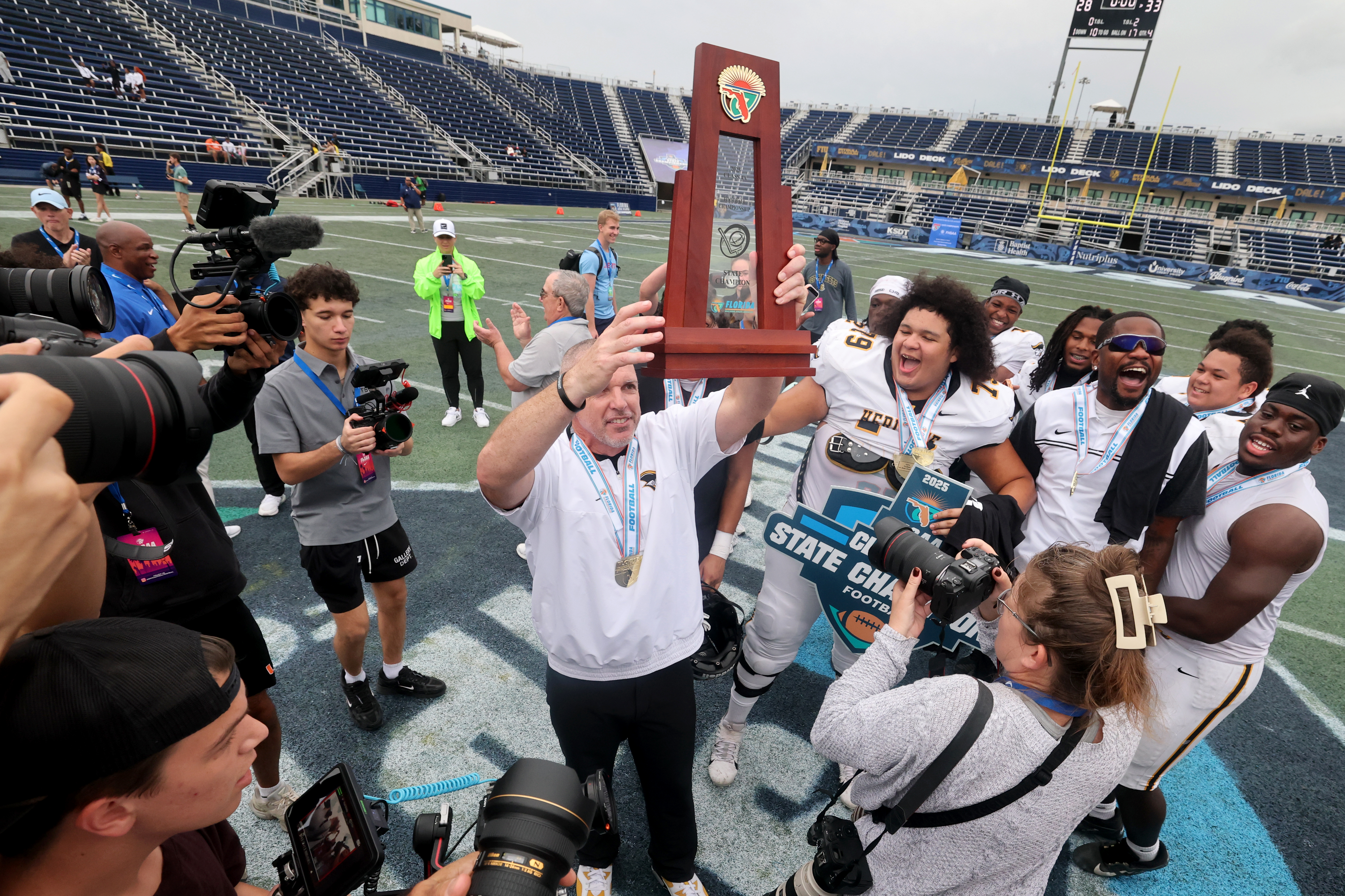 American Heritage High Schoolâs coach Mike Smith along with his...