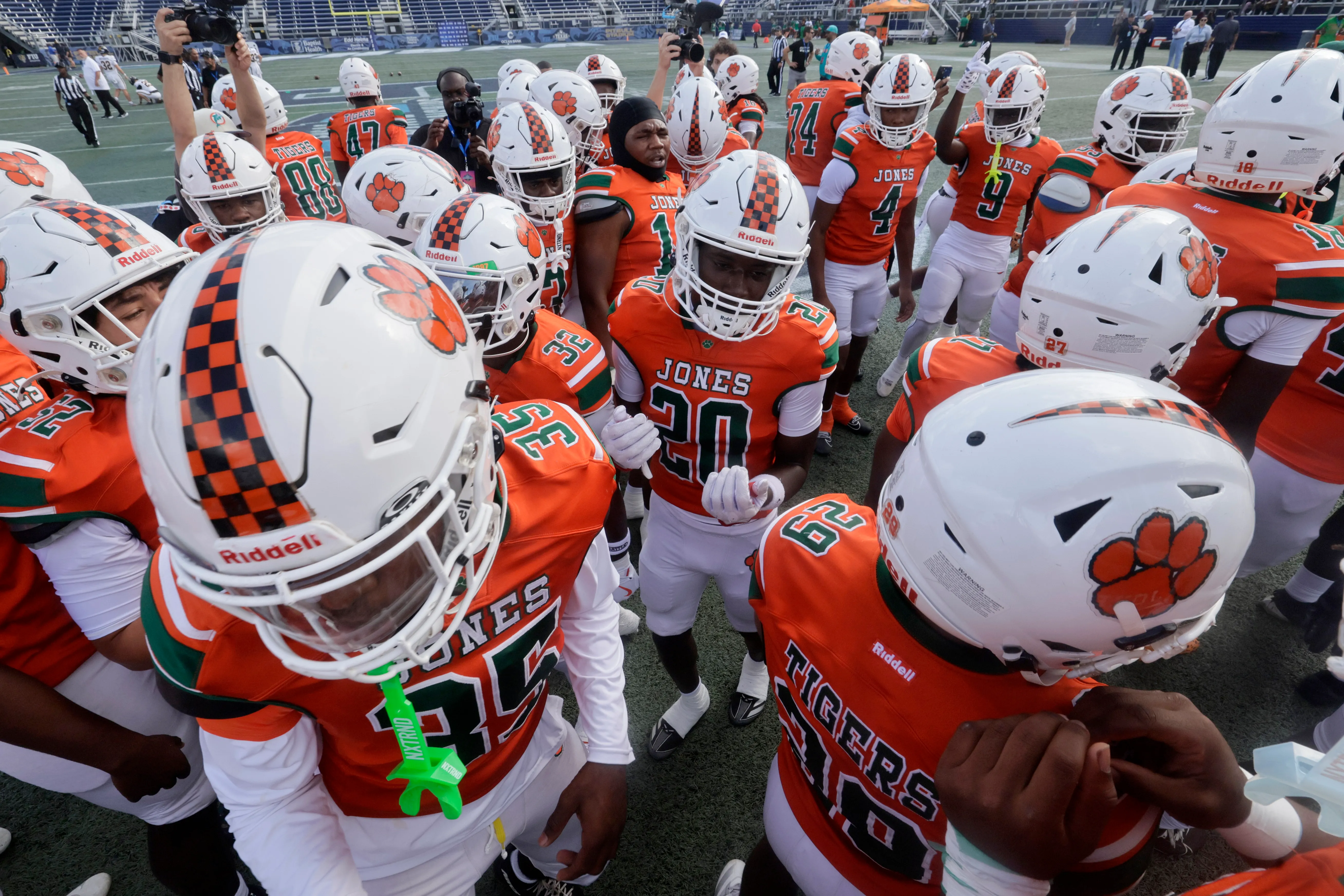 The Jones High School football team warms up for their...