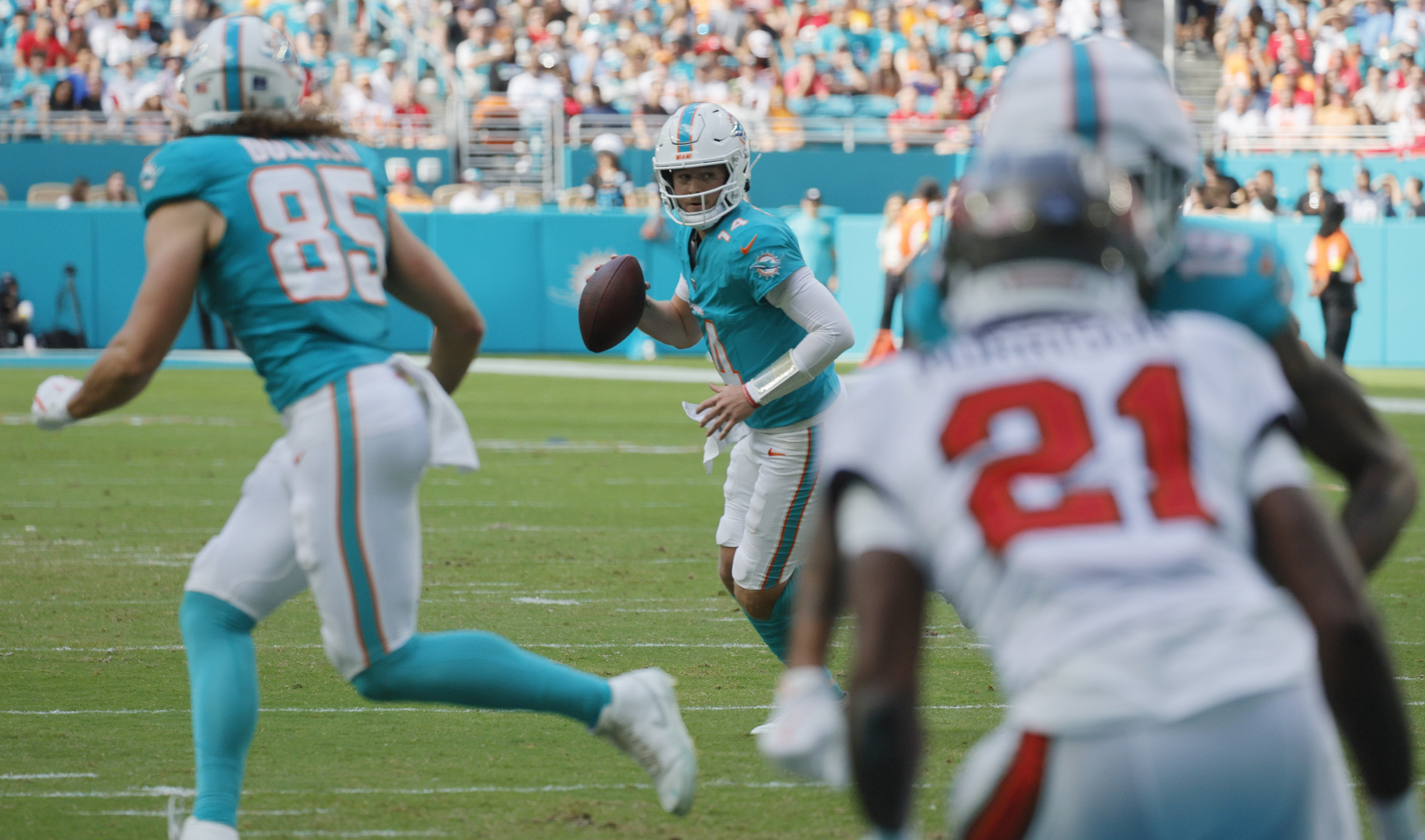 Miami Dolphins quarterback Quinn Ewers (14) rolls out top pass...
