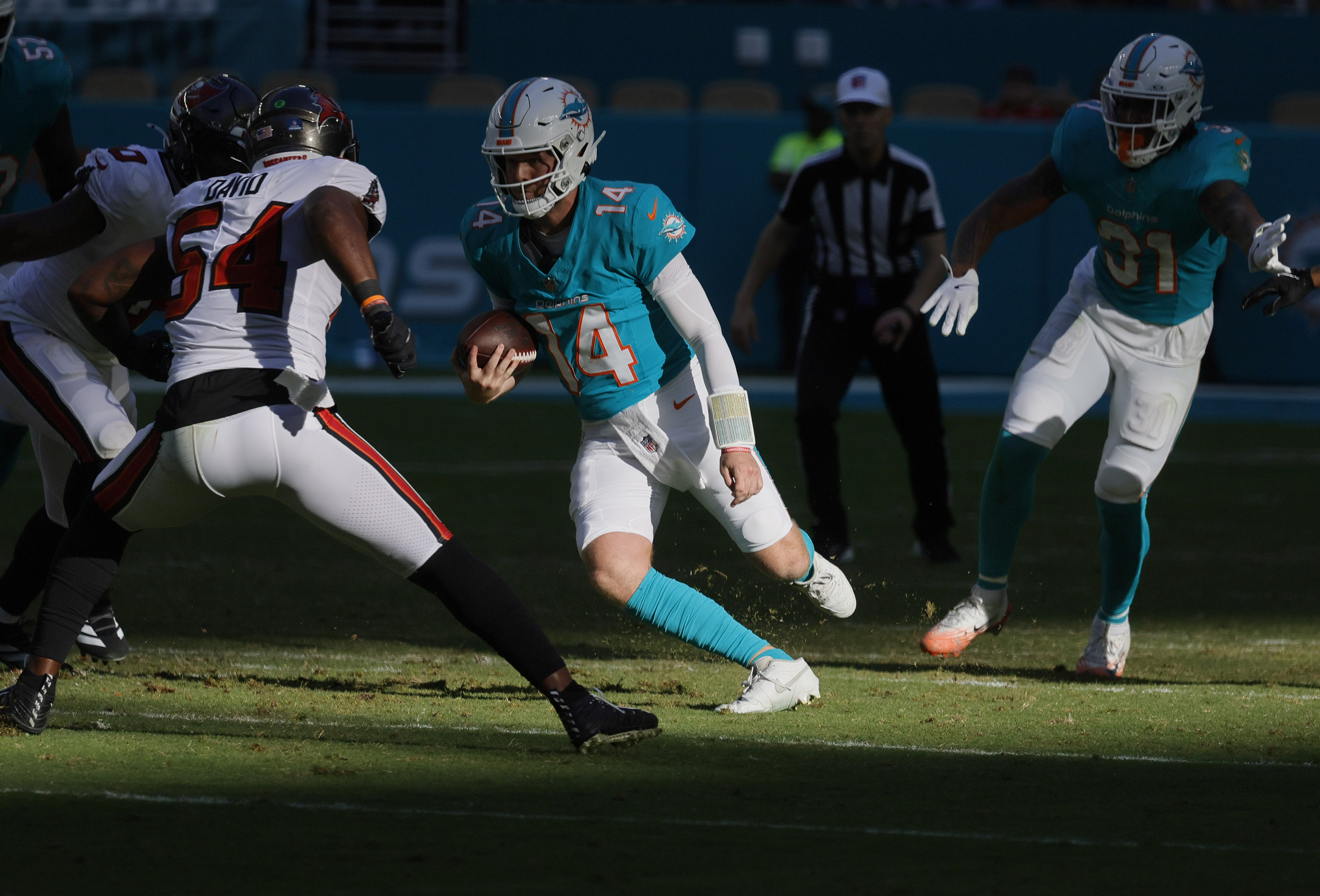 Miami Dolphins quarterback Quinn Ewers (14) runs for a first...