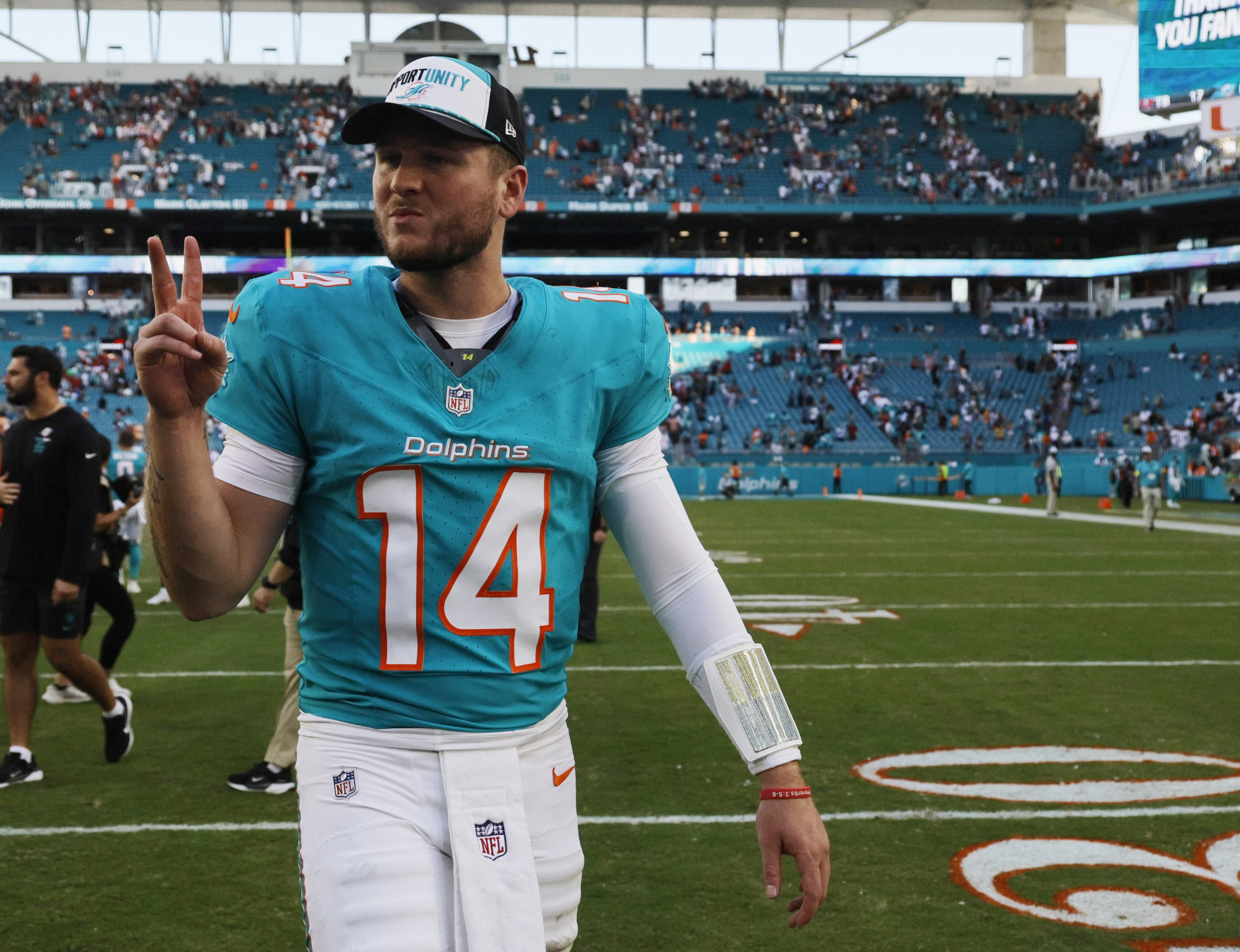 Miami Dolphins quarterback Quinn Ewers (14) walks off the field...