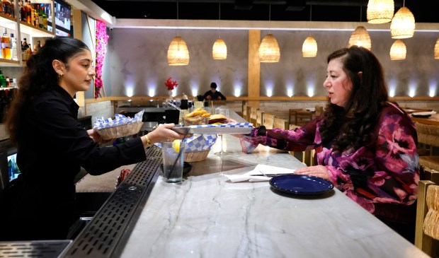 Delia Caccaviello serves Beverly To as she dines alone at Greek Joint Kitchen and Bar in Davie on Tuesday, June 3, 2025. (Carline Jean/South Florida Sun Sentinel)