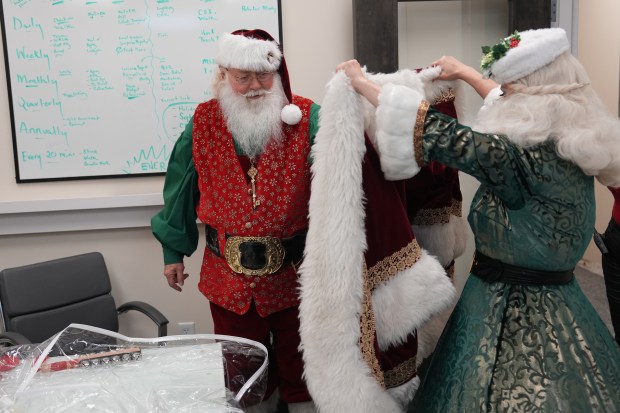 Richard Adler and Camille Terry get ready to play Santa and Mrs. Claus during a Christmas tree lighting ceremony last month at the Promenade at Coconut Creek. (Jim Rassol/Contributor)