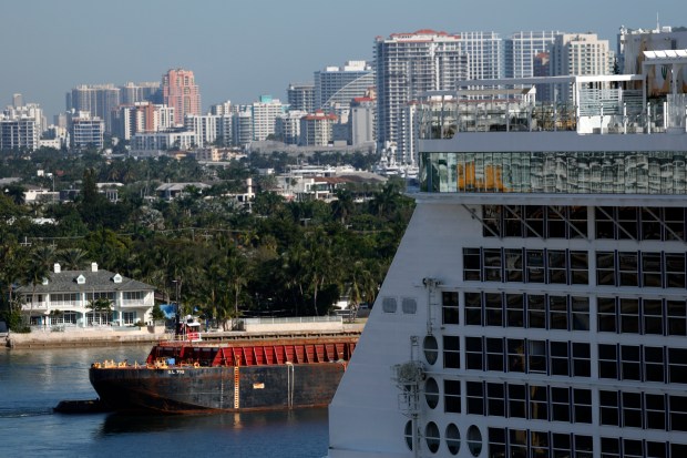 A barge motors around the Celebrity Ascent cruise ship docked at Port Everglades on Friday, Dec. 12, 2025. (Amy Beth Bennett / South Florida Sun Sentinel)