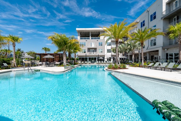 NOVEL Nona features a saltwater pool with cabanas and hammocks overlooking a pond, pedestrian trail, and conservation area. (Courtesy of Crescent Communities)