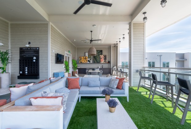One of the community's premium amenities is the top-floor resident sky lounge with televisions, card table, and a craft cocktail bar. (Courtesy of Crescent Communities)