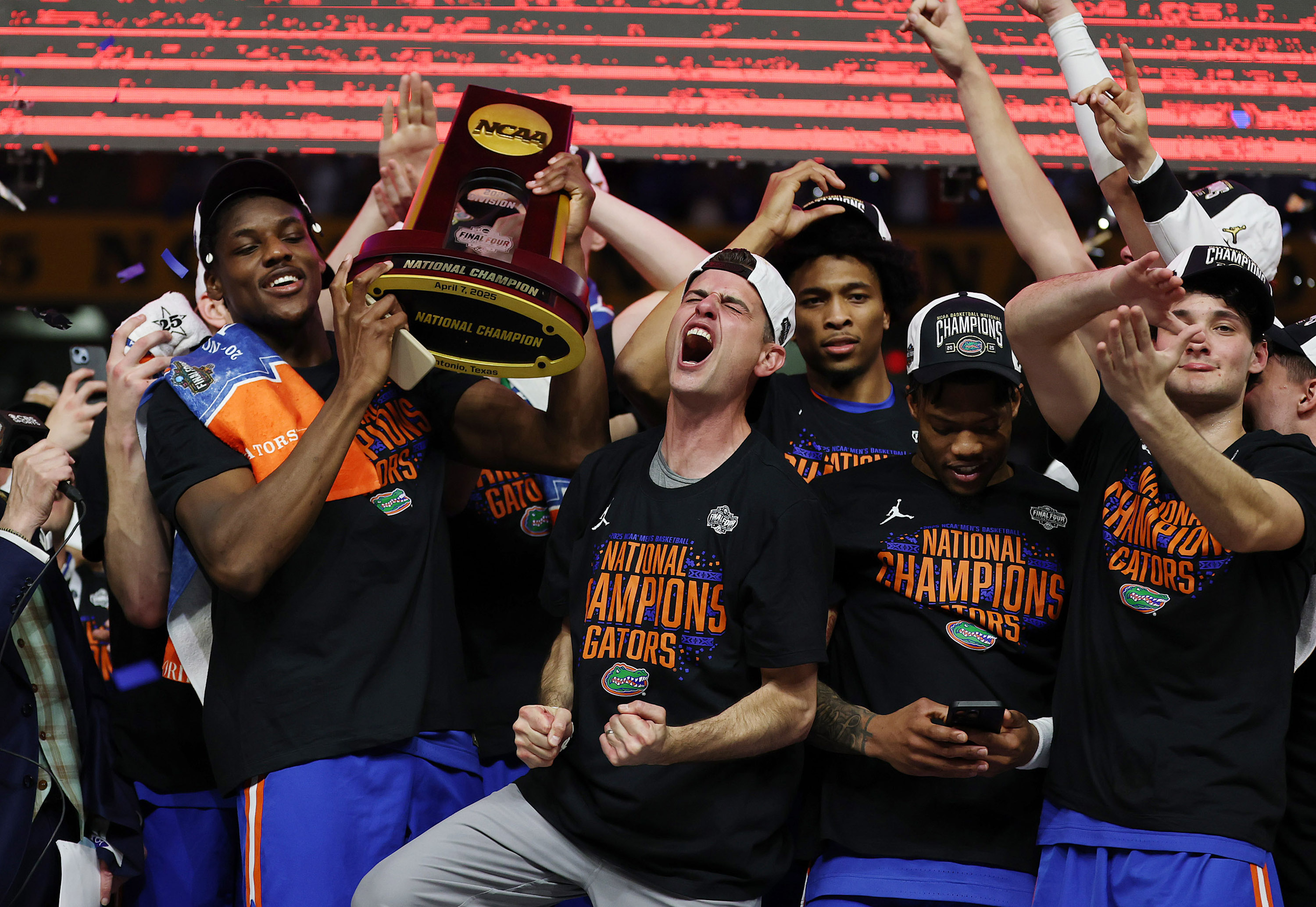Florida head coach Todd Golden, middle, screams as he and...