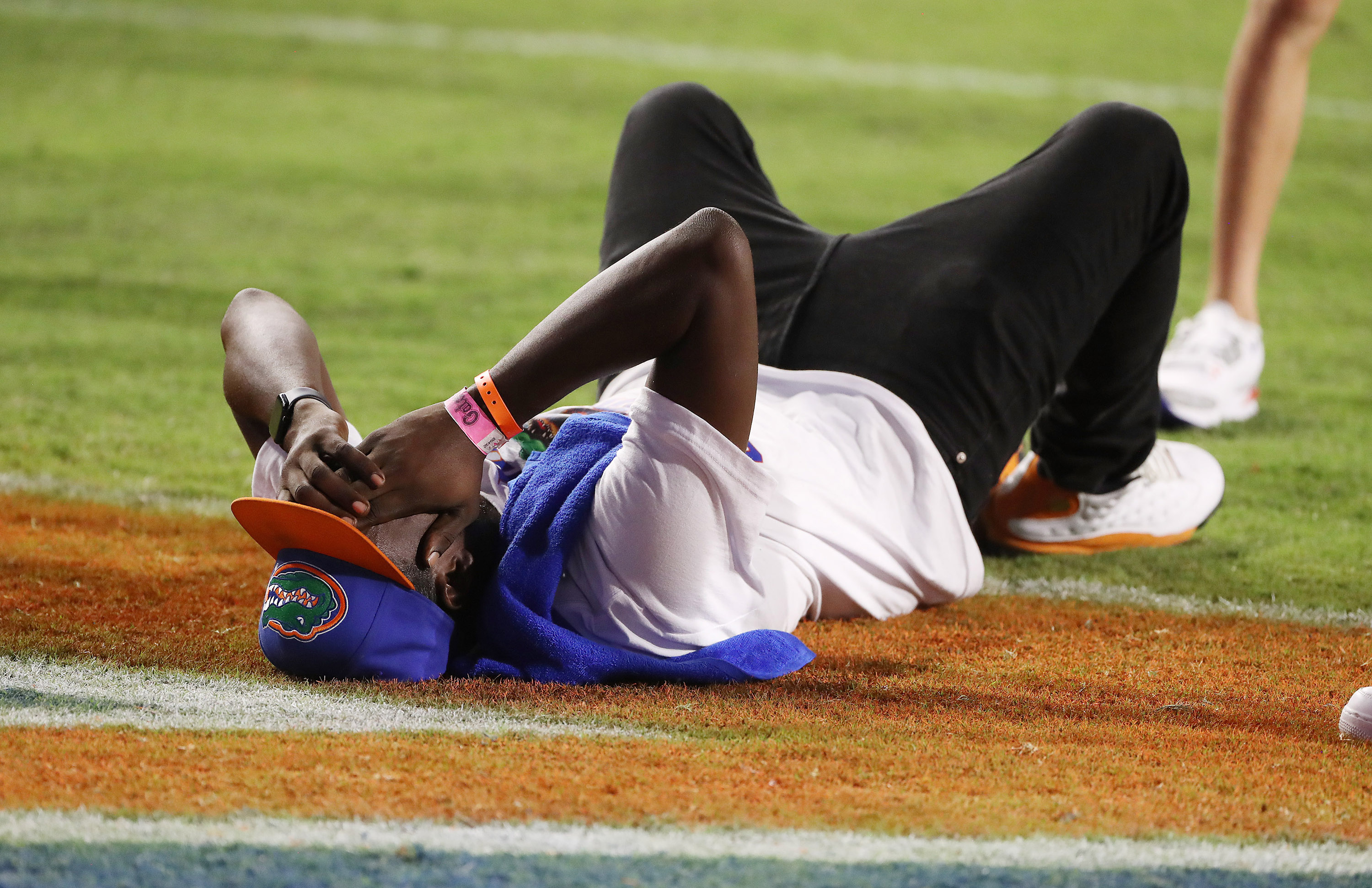An unknown Florida fan lies on the field after Florida...