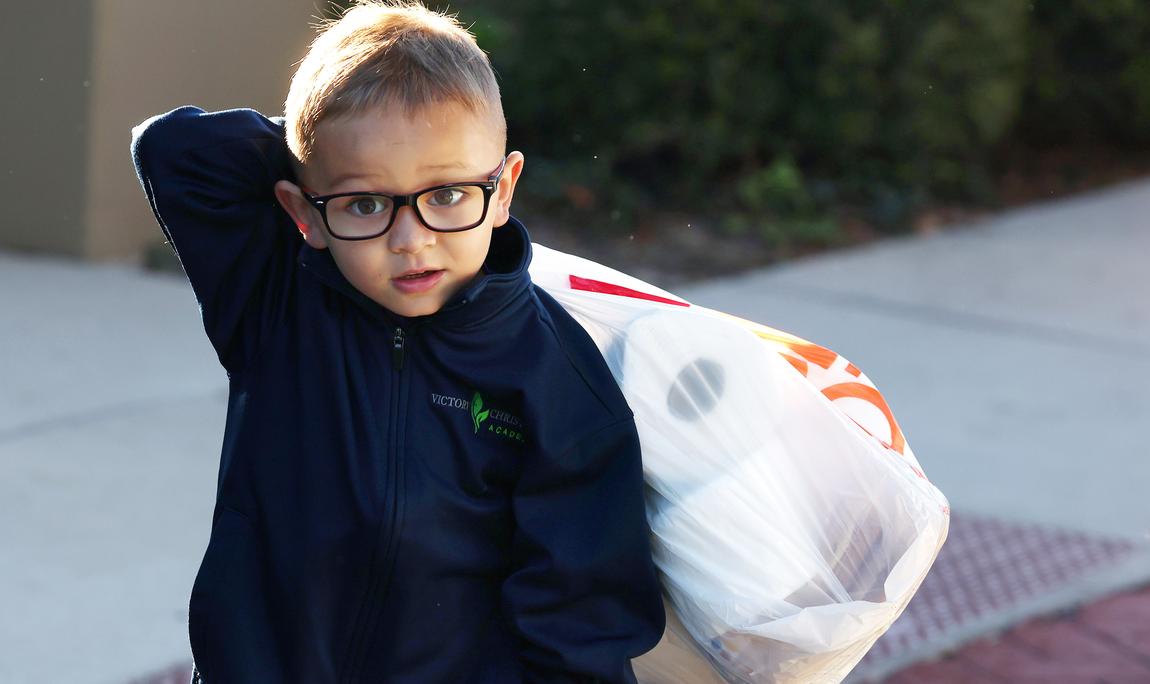 5-year-old Benjamin Jungwirth carries a bag of food and home...